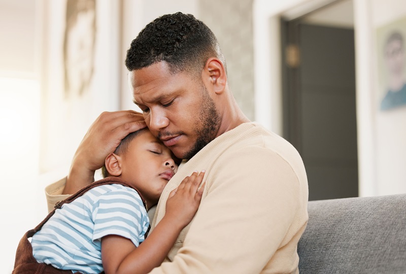 Father holding his son in an embrace.