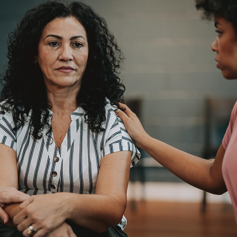 Upset woman being comforted by others